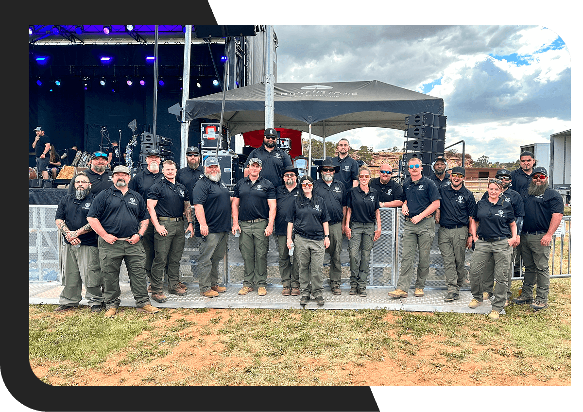 Group of people posing near outdoor stage.